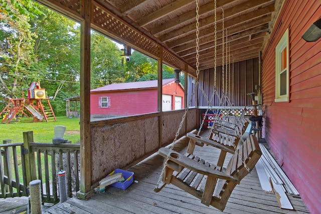 wooden deck featuring an outbuilding, a yard, and a playground