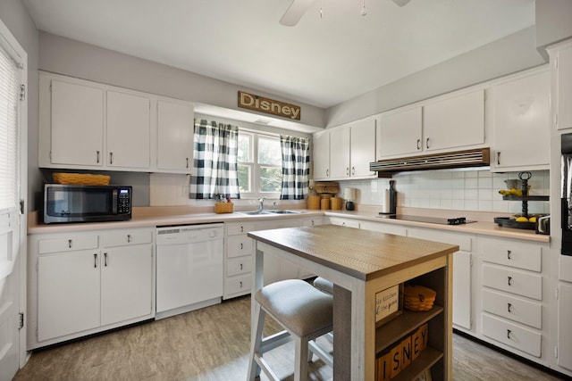 kitchen featuring sink, tasteful backsplash, black appliances, light hardwood / wood-style floors, and white cabinets