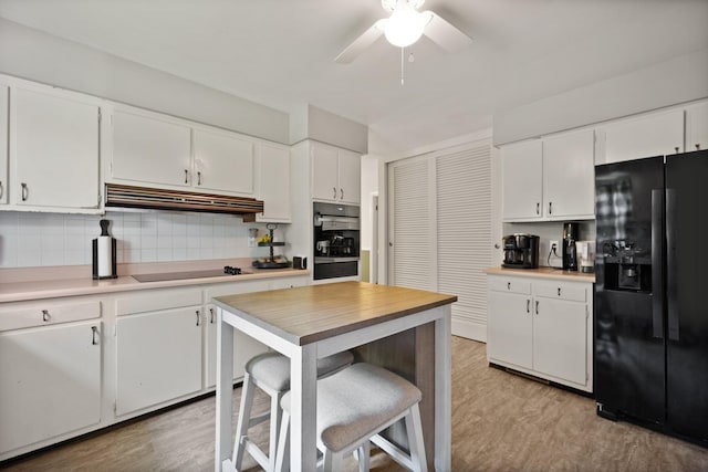 kitchen featuring black appliances, backsplash, white cabinets, ceiling fan, and light hardwood / wood-style floors