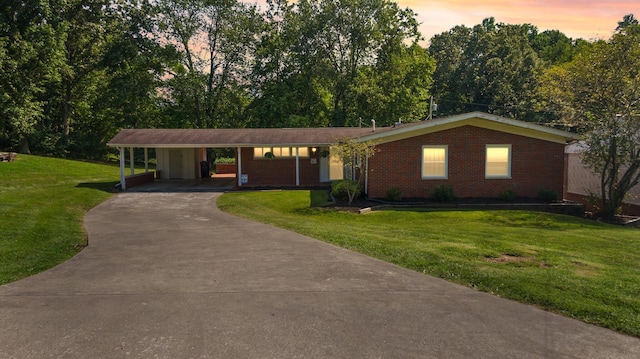 single story home featuring a carport and a yard