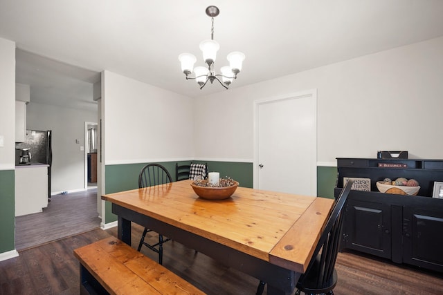 dining space with dark wood-type flooring and a notable chandelier