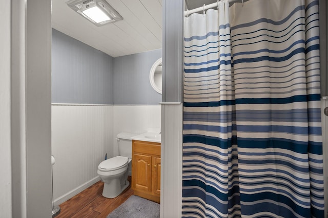 bathroom featuring vanity, toilet, curtained shower, and hardwood / wood-style floors