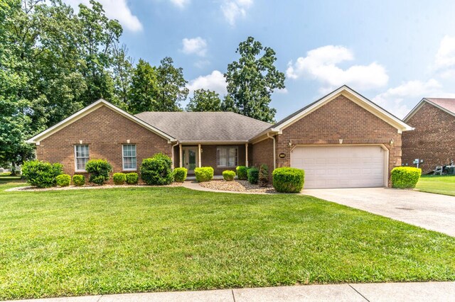 ranch-style house with a garage and a front lawn