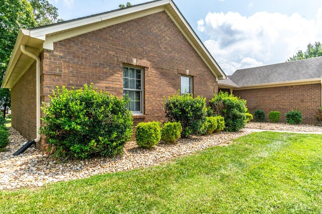 view of side of home with a lawn