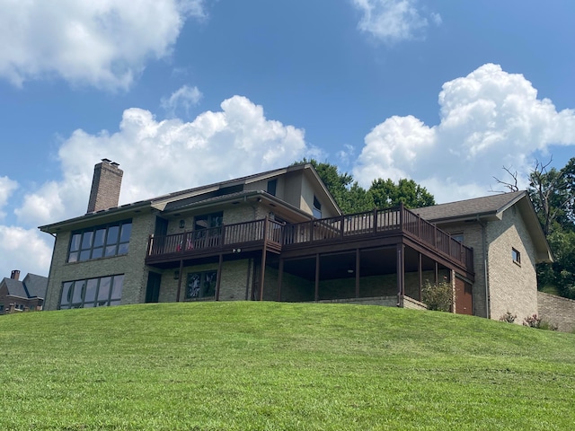 rear view of property with a deck and a lawn