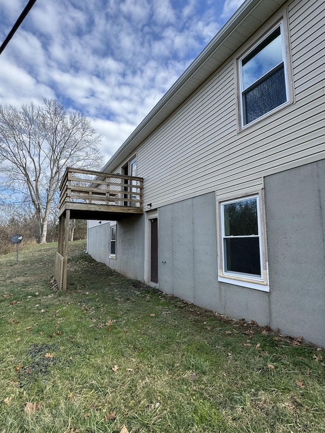 view of side of property with a deck and a yard