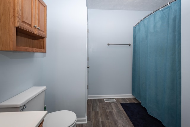 bathroom with vanity, toilet, and hardwood / wood-style flooring