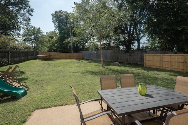 view of yard featuring a playground and a patio