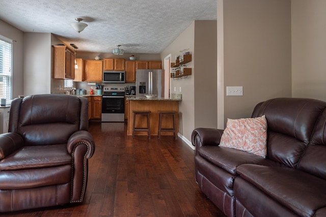 living room featuring dark wood-type flooring and a textured ceiling