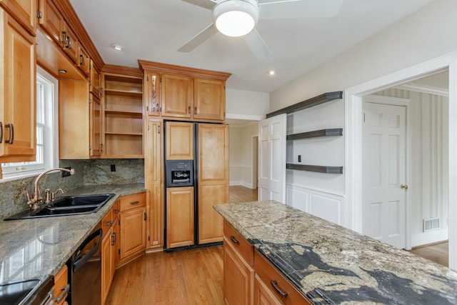 kitchen featuring paneled built in refrigerator, sink, black dishwasher, and stone counters