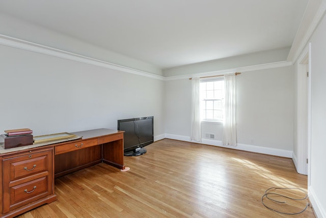 home office with ornamental molding and light hardwood / wood-style floors