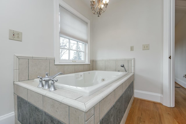 bathroom featuring tiled bath and hardwood / wood-style floors