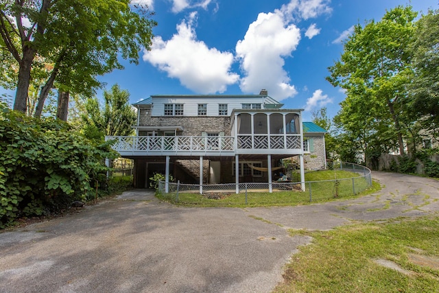 back of house featuring a wooden deck and a sunroom