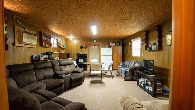 carpeted living room with a textured ceiling, wooden walls, and a wall mounted AC