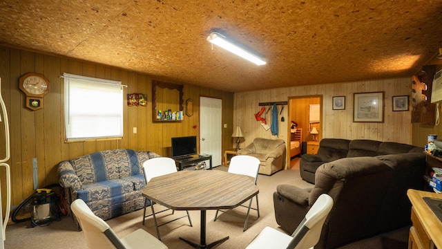 living room featuring light carpet and wooden walls