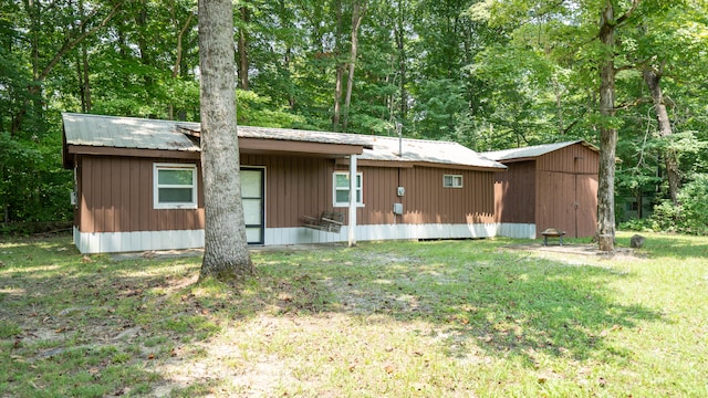 rear view of house featuring a lawn