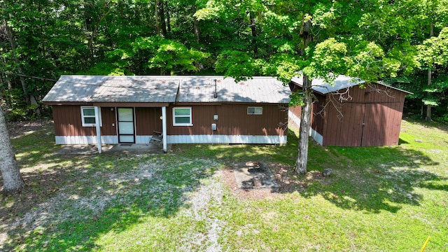 view of front of house with a front yard and an outdoor structure