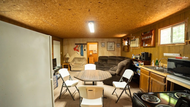 living area with sink, light colored carpet, and wood walls