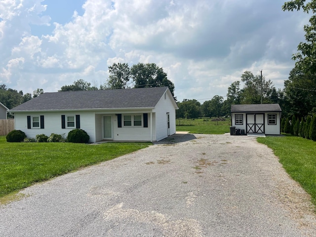 view of front of property featuring a front yard and a storage unit