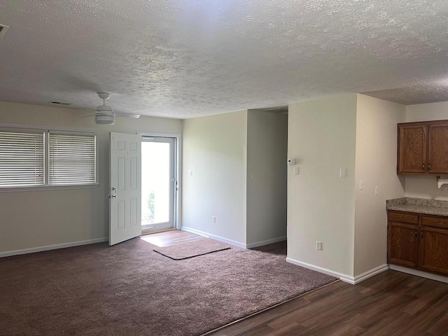 interior space featuring ceiling fan, dark hardwood / wood-style floors, and a textured ceiling