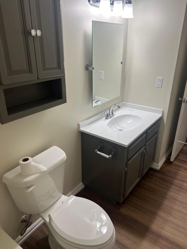 bathroom with vanity, hardwood / wood-style flooring, and toilet