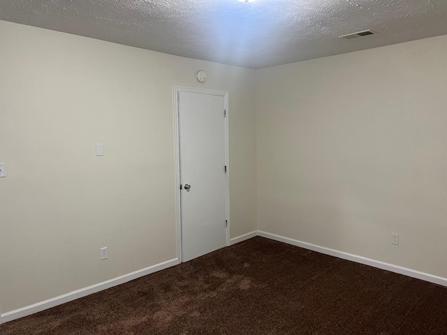 unfurnished room featuring a textured ceiling and carpet