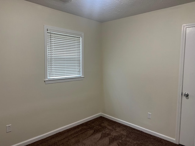 carpeted empty room with a textured ceiling