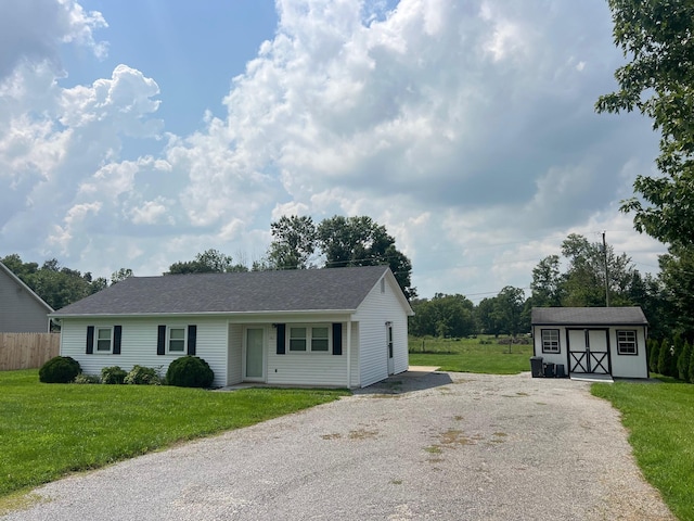 view of front facade featuring a front yard and a shed