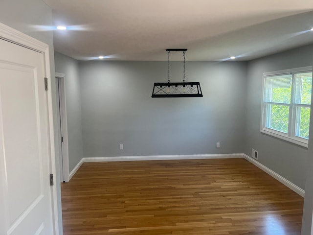 unfurnished dining area featuring wood-type flooring