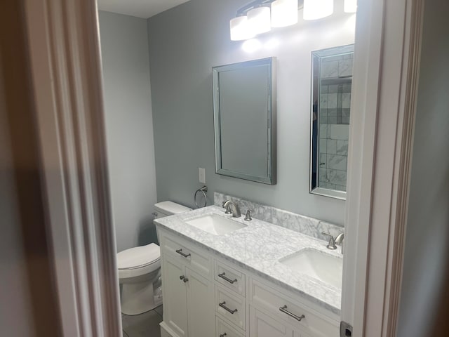 bathroom with dual vanity and toilet