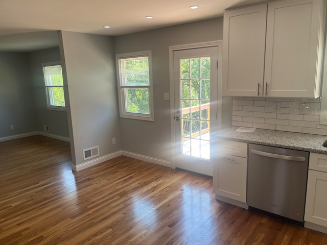 kitchen with stainless steel dishwasher, tasteful backsplash, and dark wood-type flooring