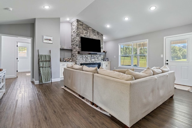 living room with a fireplace, dark wood-type flooring, and vaulted ceiling