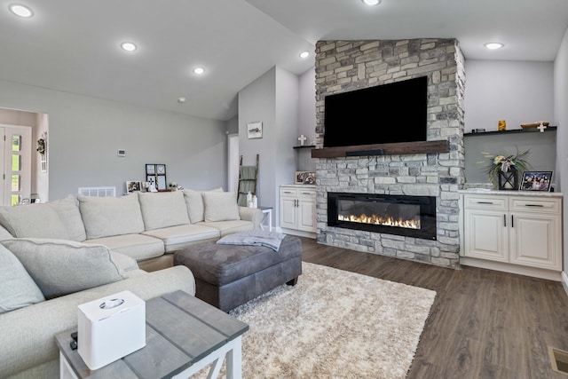 living room featuring lofted ceiling, dark hardwood / wood-style flooring, and a fireplace