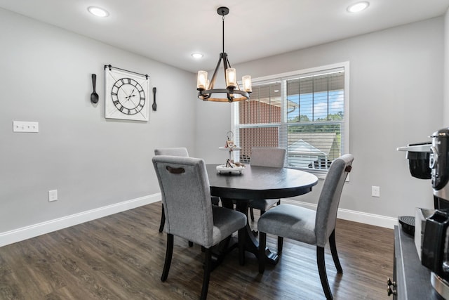 dining area with dark hardwood / wood-style flooring and a chandelier