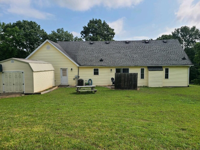 back of house featuring a yard and a storage shed