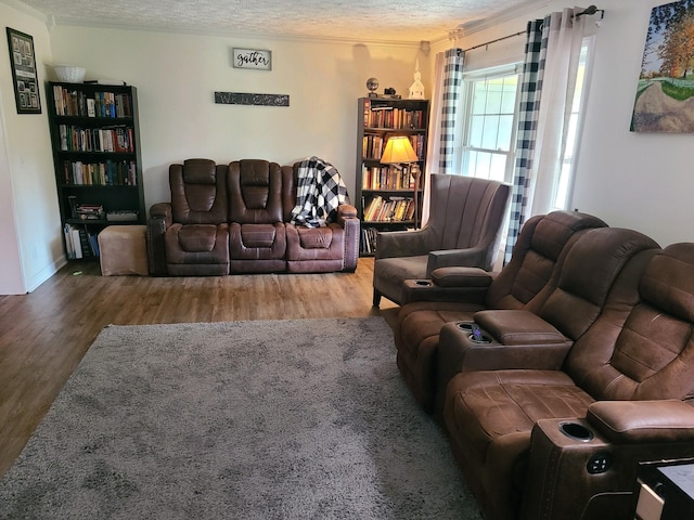 living room with a textured ceiling, crown molding, and hardwood / wood-style floors