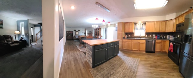 kitchen with a chandelier, hardwood / wood-style flooring, black appliances, decorative light fixtures, and sink