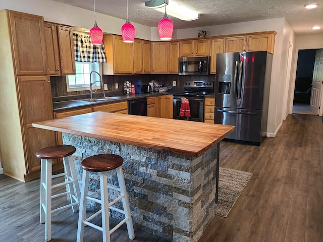 kitchen with dark wood-type flooring, a kitchen breakfast bar, sink, tasteful backsplash, and black appliances