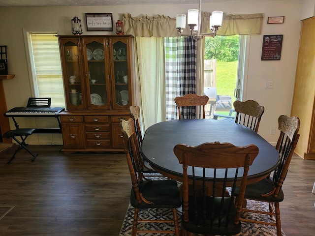 dining room featuring dark wood-type flooring and a chandelier