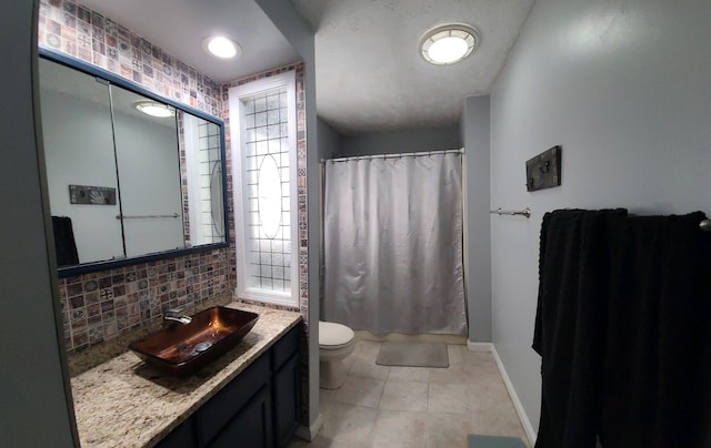 bathroom featuring decorative backsplash, toilet, tile patterned floors, and vanity