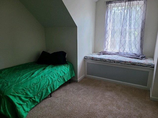 carpeted bedroom with vaulted ceiling and multiple windows