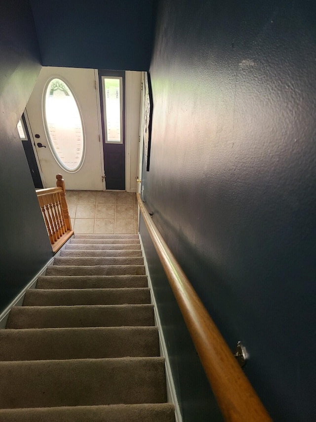 stairs featuring a towering ceiling and tile patterned flooring