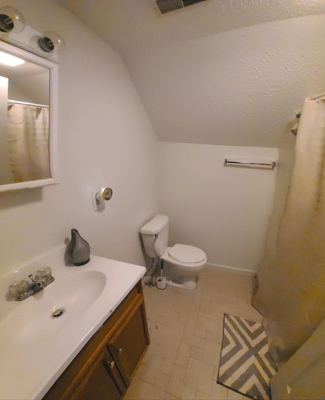 bathroom with vanity, vaulted ceiling, tile patterned flooring, and toilet