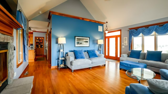 living room featuring ceiling fan, high vaulted ceiling, hardwood / wood-style flooring, and a premium fireplace