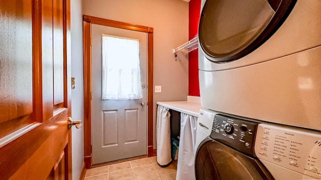 laundry area with light tile patterned floors and stacked washer / drying machine