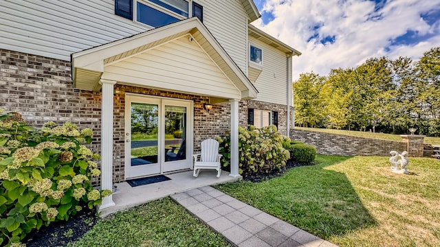 view of exterior entry with a yard