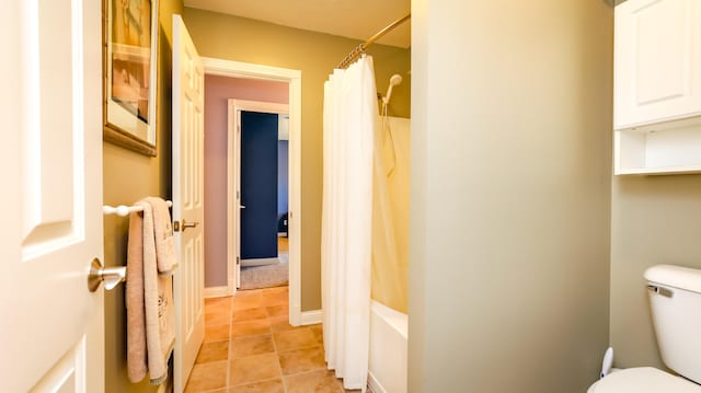 bathroom featuring shower / bath combo with shower curtain, tile patterned floors, and toilet