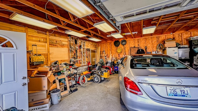 garage featuring a workshop area and wood walls