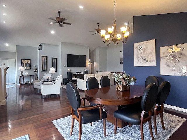 dining space with dark wood-type flooring, recessed lighting, baseboards, and ceiling fan with notable chandelier