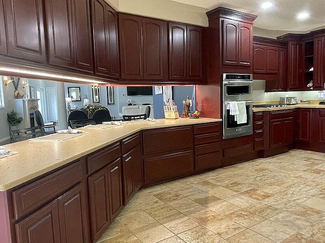 kitchen with a peninsula, stainless steel double oven, and recessed lighting